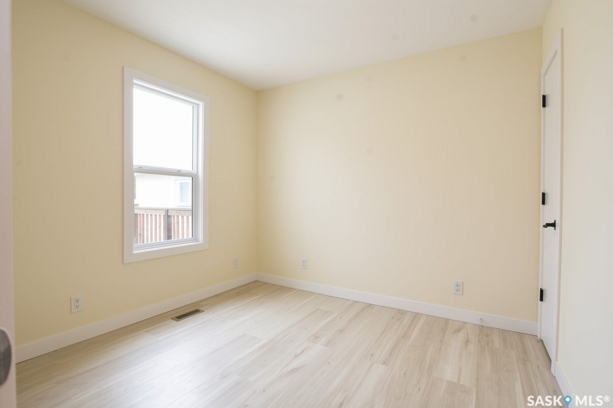 Vinyl plank flooring throughout, a white trim window, and neutral wall paint