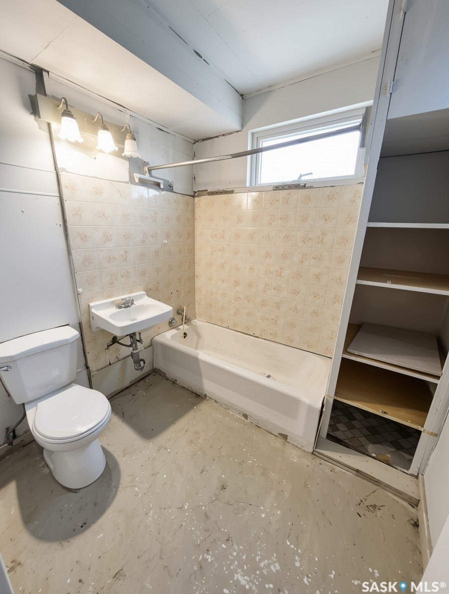 Bathroom featuring a wall-mounted sink, toilet, and built-in bathtub with tiled surround
