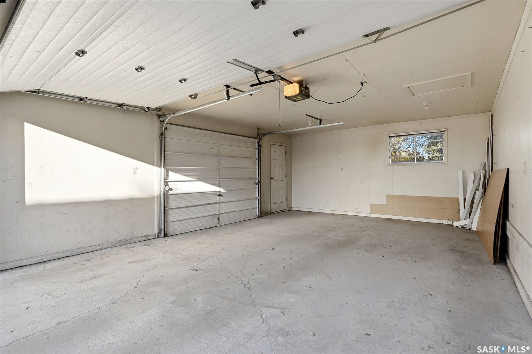 3361 Wascana Street, Regina SK S4S 2H2 Garage with a concrete floor, overhead lighting, and an automatic garage door opener
