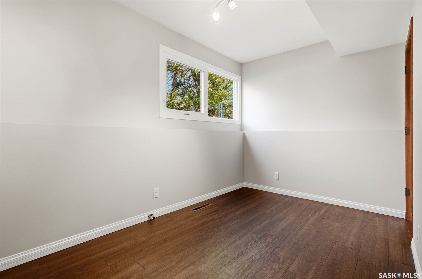 3361 Wascana Street, Regina SK S4S 2H2 Wood-finish flooring, white trim, track lighting, and a white-framed window