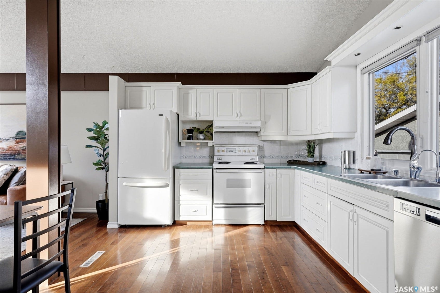 3361 Wascana Street, Regina SK S4S 2H2 Kitchen featuring wood-finish flooring, white cabinetry, white appliances, and a double basin sink