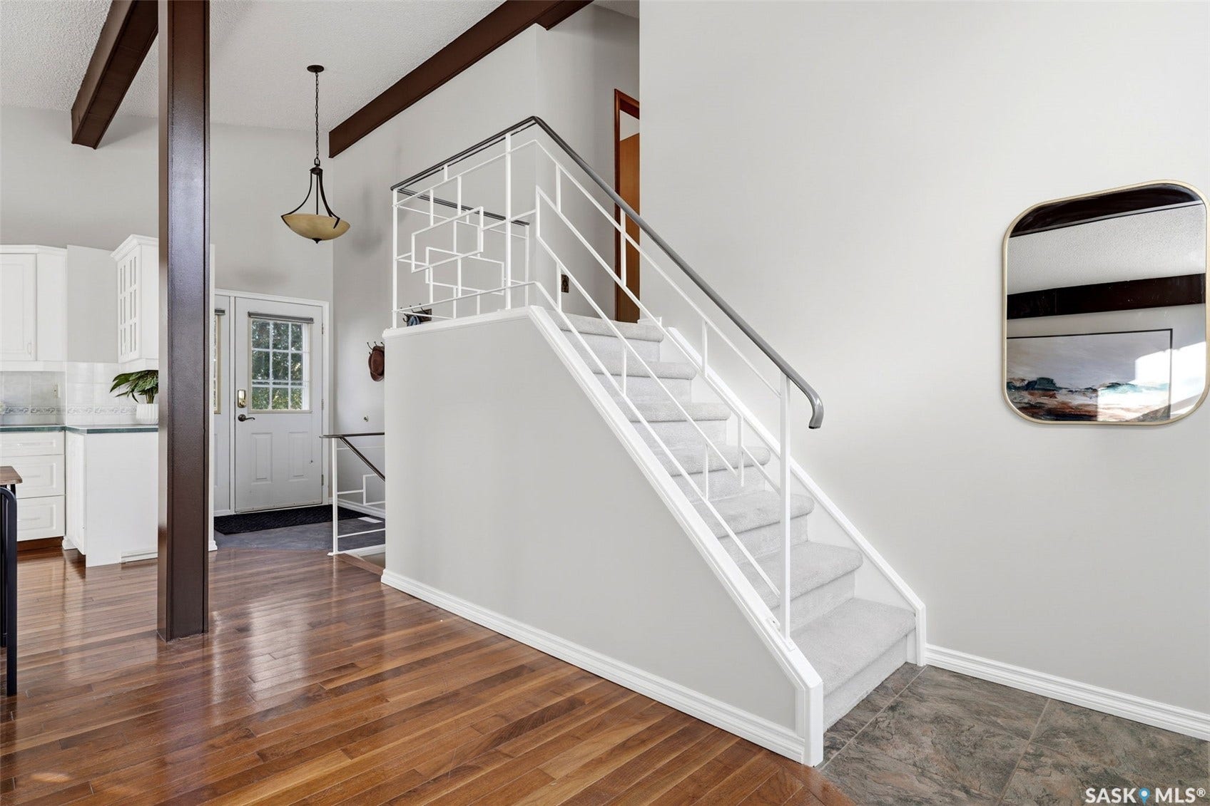 3361 Wascana Street, Regina SK S4S 2H2 Exposed ceiling beams, vaulted ceiling, wood-finish flooring, staircase with carpet treads, and a decorative metal railing