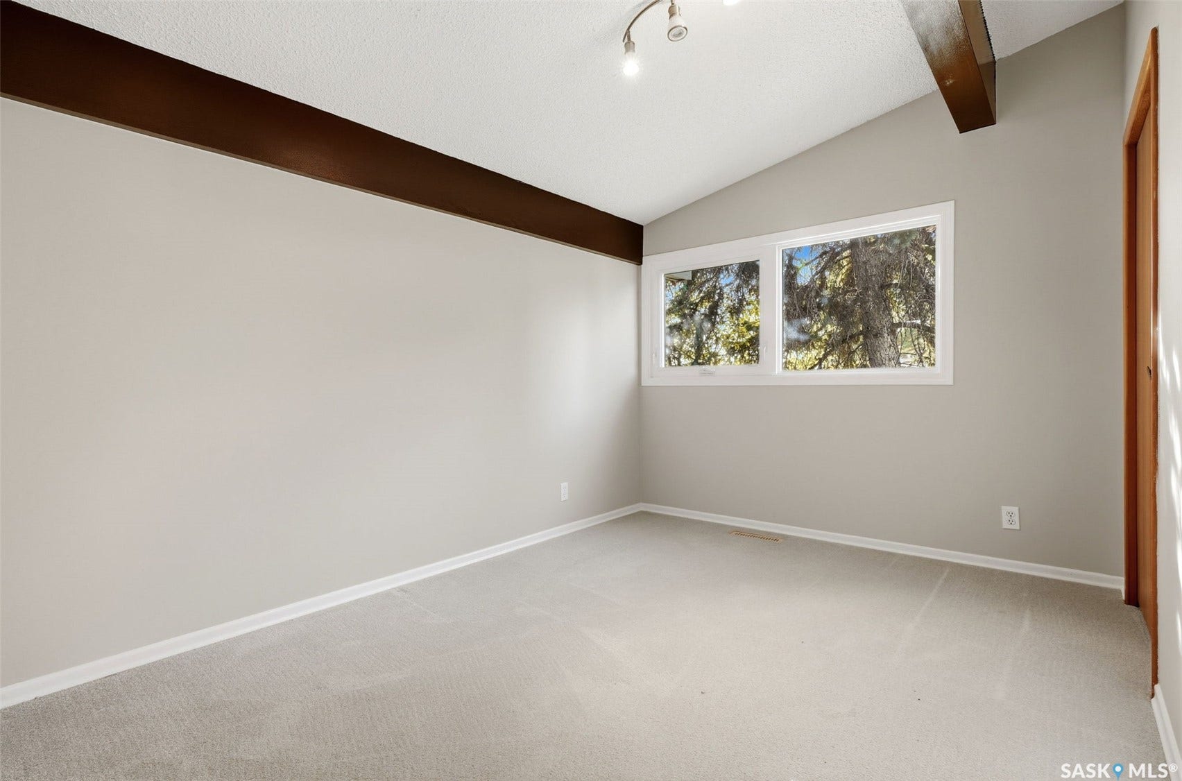 3361 Wascana Street, Regina SK S4S 2H2 Vaulted ceiling with exposed beam, dual-pane windows, and light neutral carpeting