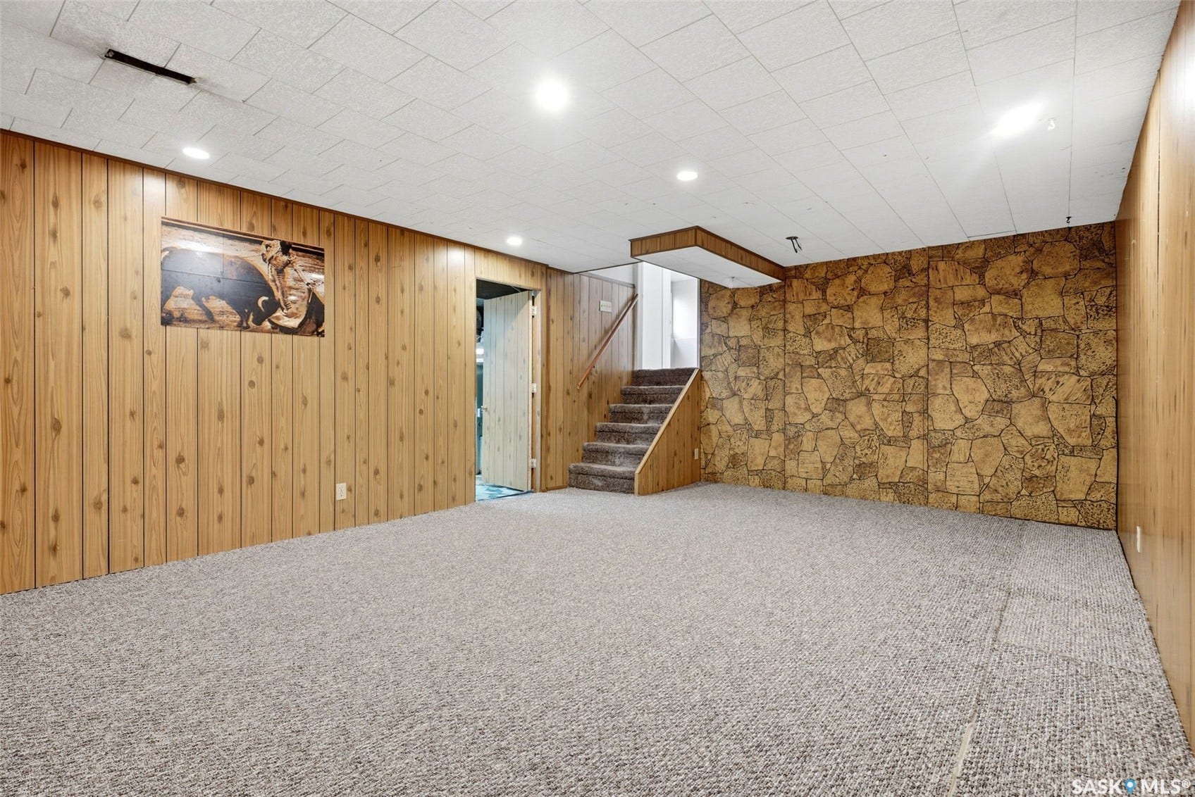 3361 Wascana Street, Regina SK S4S 2H2 Wall paneling accent, stone-patterned wall, drop ceiling with recessed lighting, carpeted flooring, and a carpeted staircase