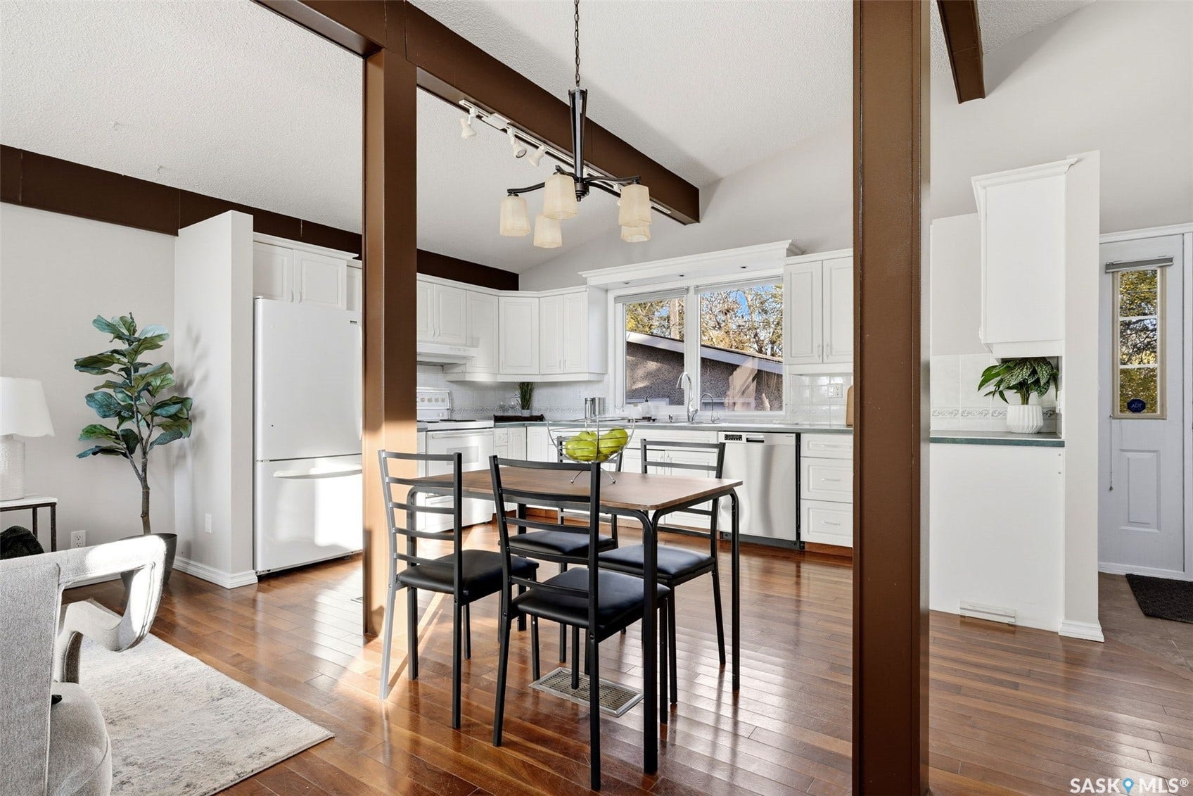 3361 Wascana Street, Regina SK S4S 2H2 Kitchen with vaulted ceiling, white cabinetry, stainless steel appliances, and wood-finish flooring