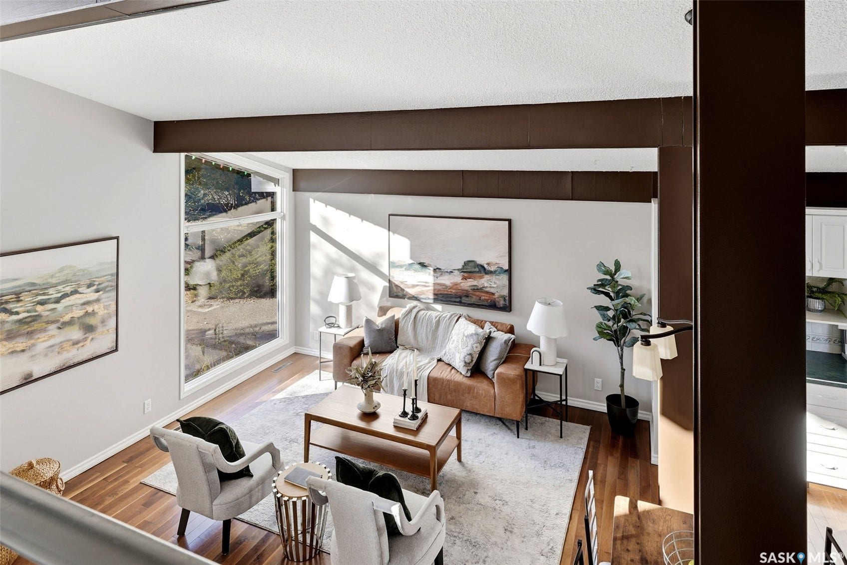 3361 Wascana Street, Regina SK S4S 2H2 Spacious living area featuring large picture windows, wood-finish flooring, and exposed ceiling beams