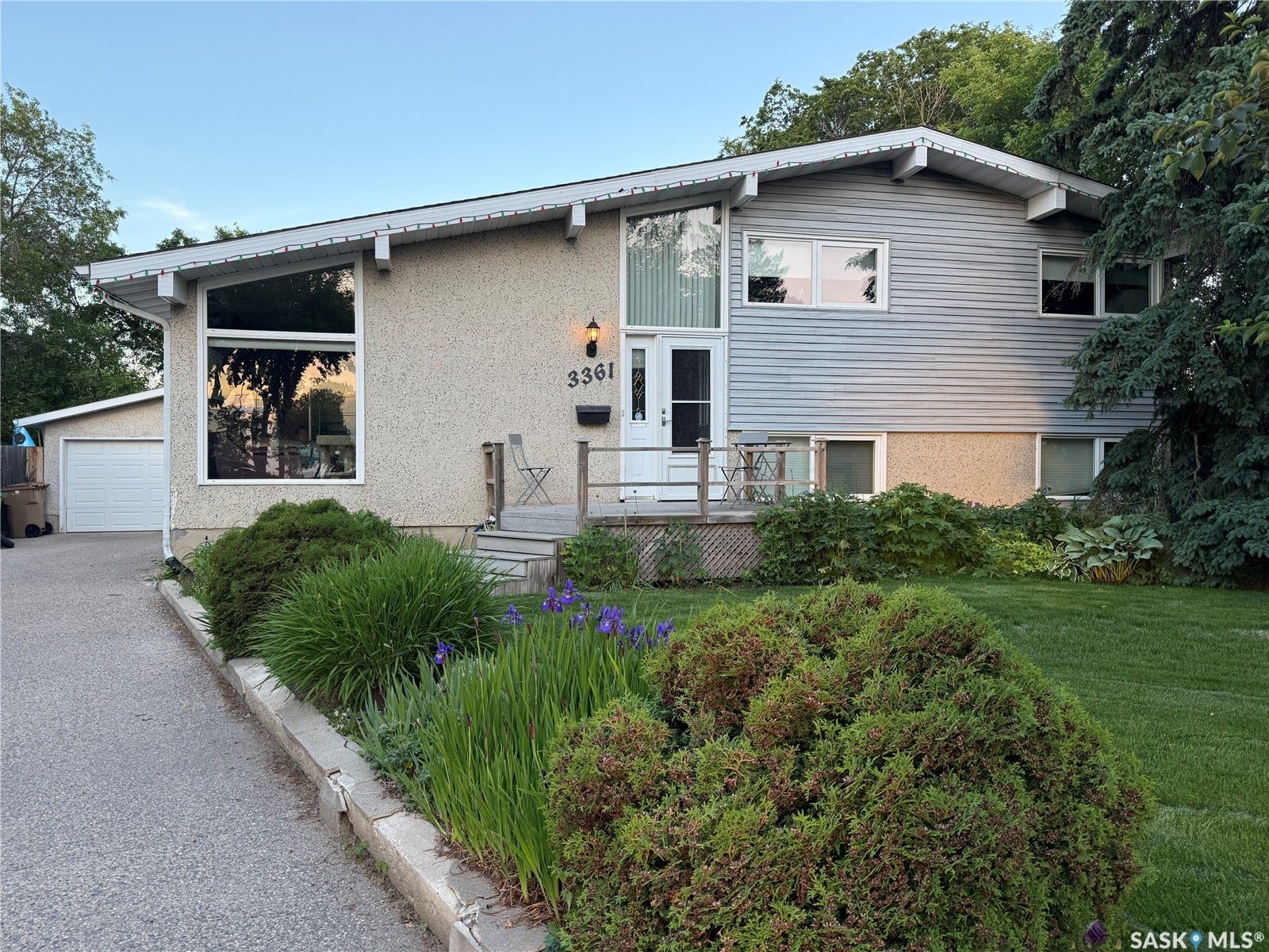 3361 Wascana Street, Regina SK S4S 2H2 Split-level residence featuring a combination of stucco and siding exterior finishes, a front deck, and a detached garage