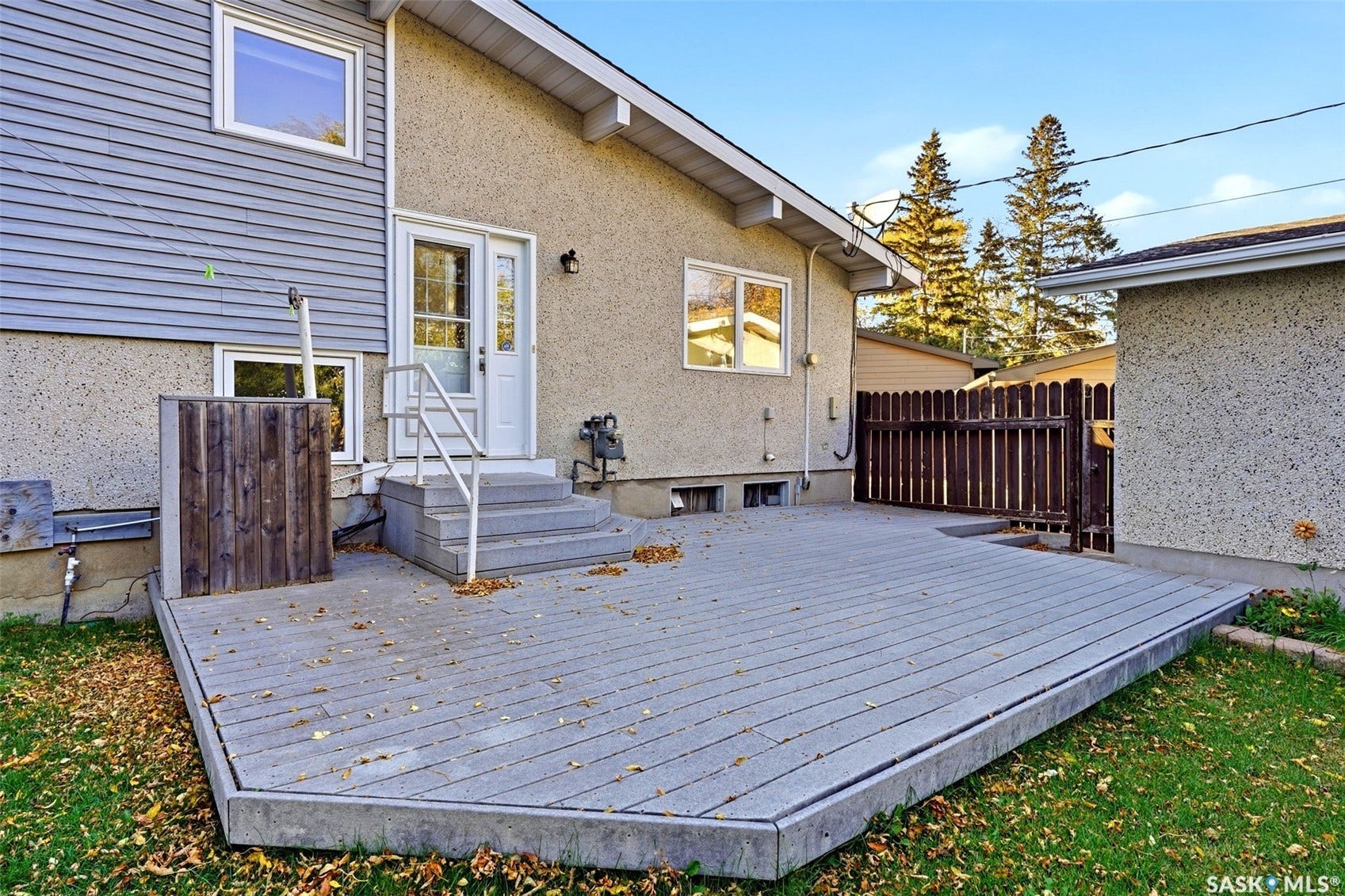 3361 Wascana Street, Regina SK S4S 2H2 Expansive exterior deck with steps and a white handrail, featuring a durable surface