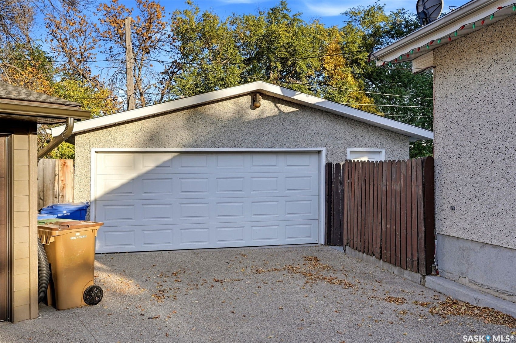3361 Wascana Street, Regina SK S4S 2H2 Detached garage with a paneled door, stucco exterior, and sloped roofline
