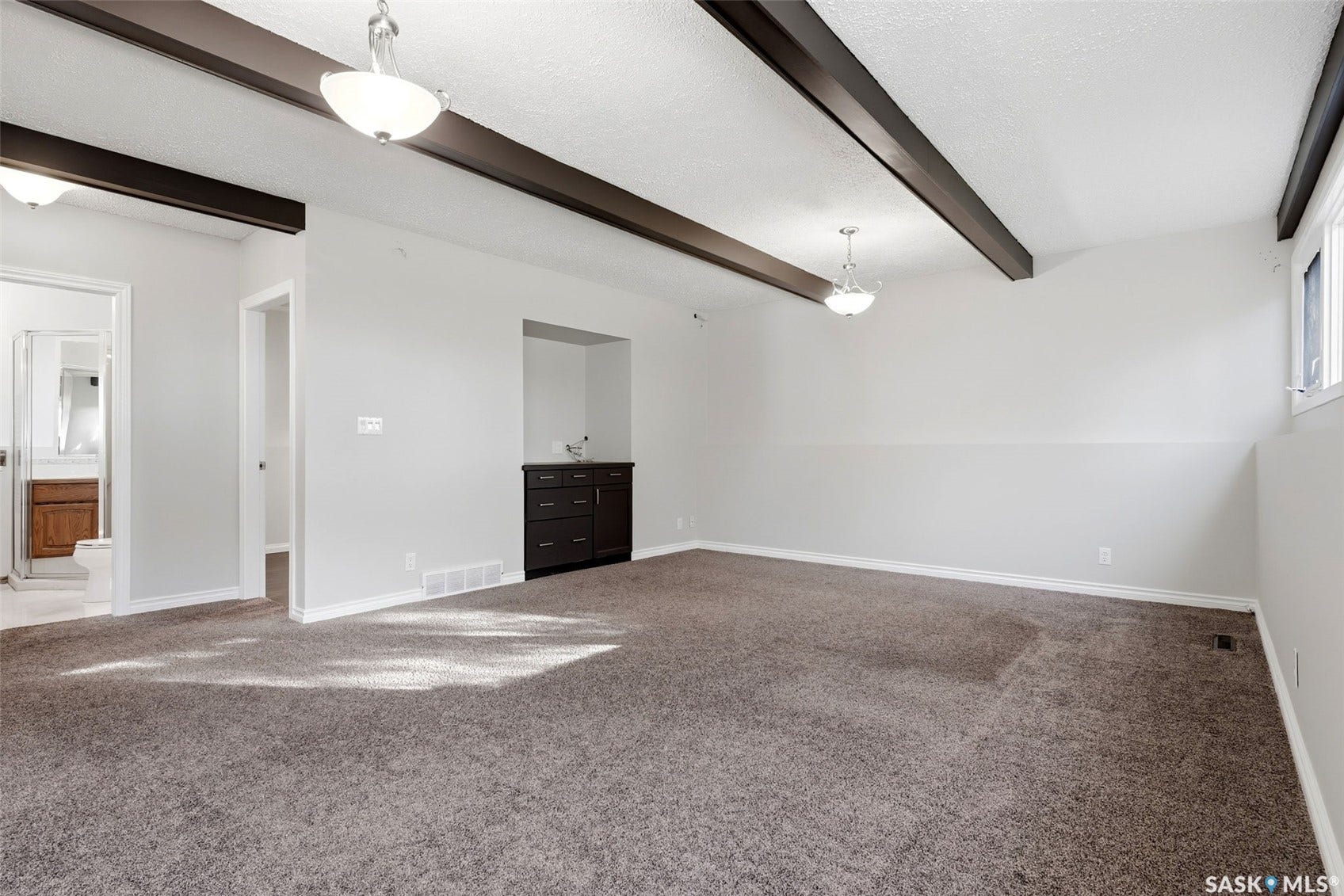 3361 Wascana Street, Regina SK S4S 2H2 Vaulted ceiling with exposed beams, recessed built-in cabinetry, and neutral wall tones