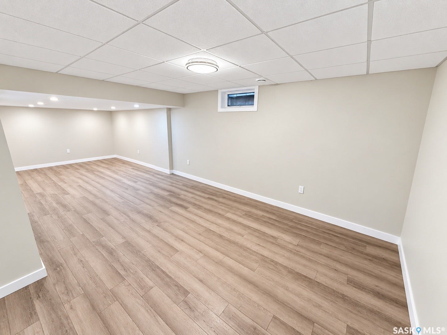 5810 Sherwood Drive, Regina SK S4T 6Y7 Spacious room with wood-finish flooring, recessed lighting, drop ceiling, and a high-set window