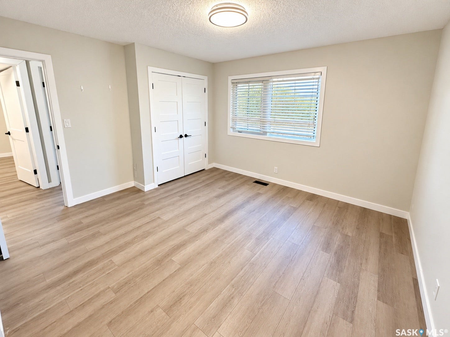 5810 Sherwood Drive, Regina SK S4T 6Y7 Wood-finish flooring, white trim, and neutral wall paint