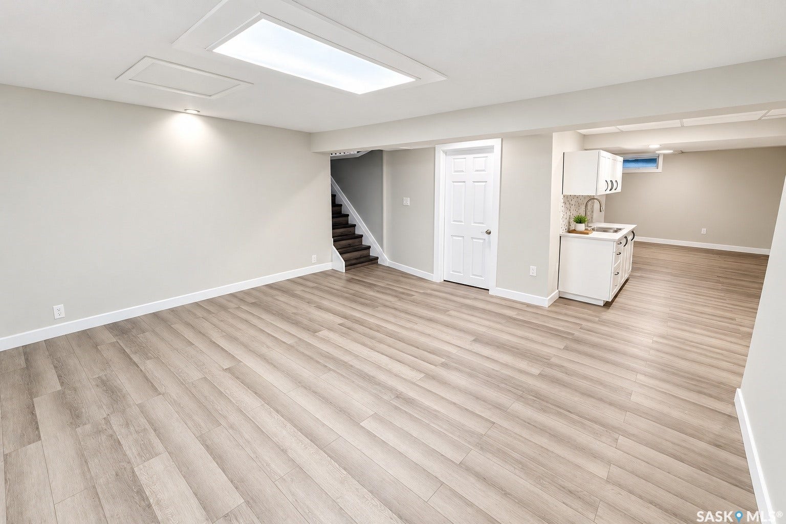 5810 Sherwood Drive, Regina SK S4T 6Y7 Expansive room featuring wood-finish flooring, white walls, and recessed lighting