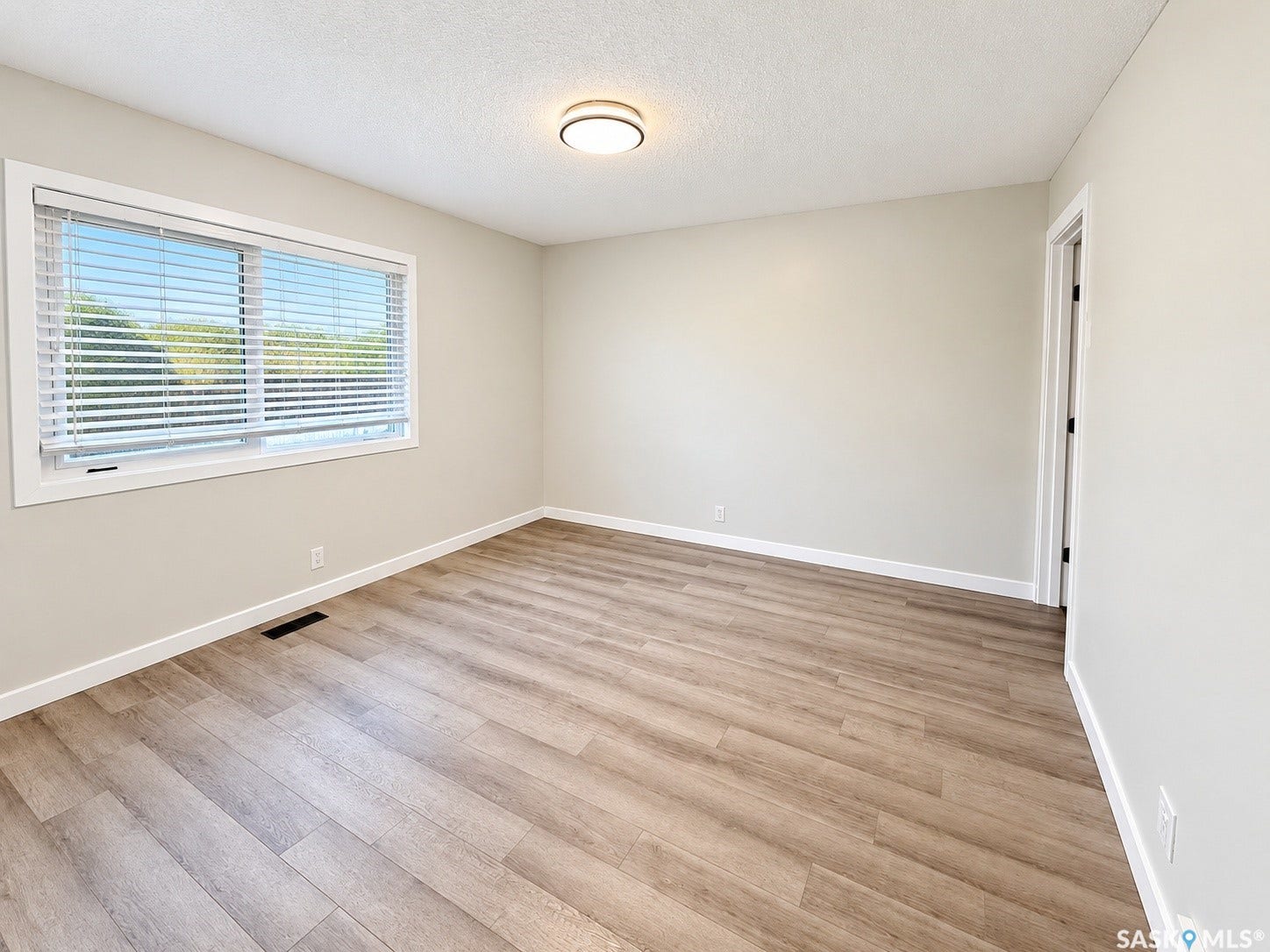 5810 Sherwood Drive, Regina SK S4T 6Y7 Recessed lighting fixture, wood-finish flooring, white trim, and a window with blinds