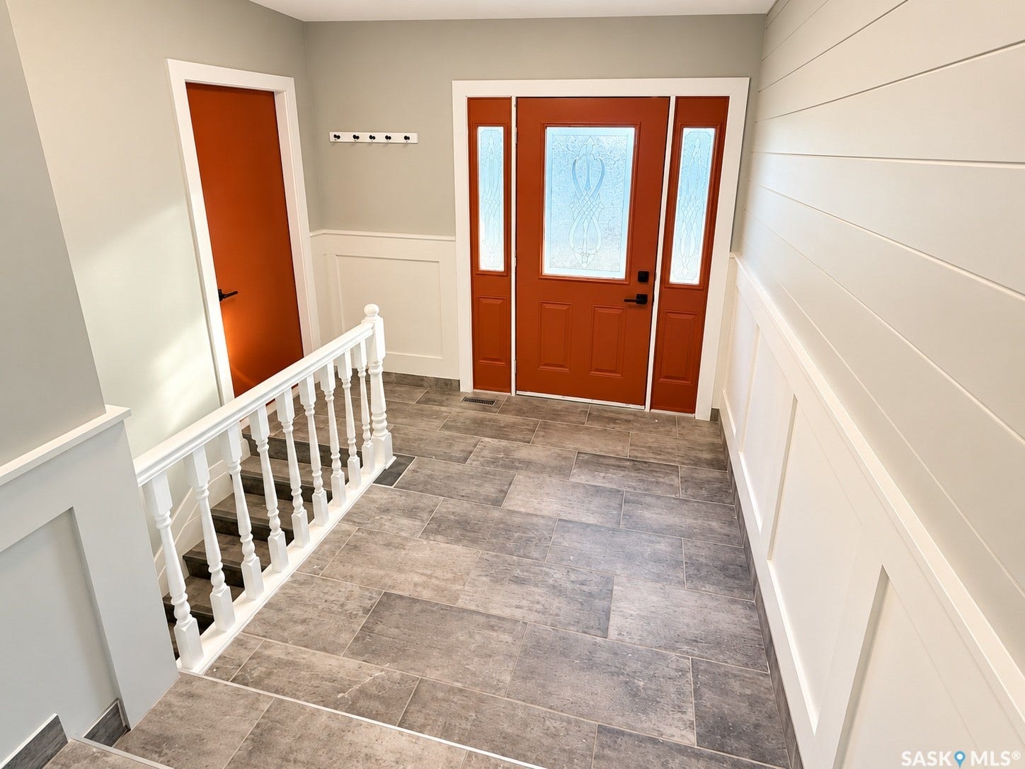 5810 Sherwood Drive, Regina SK S4T 6Y7 Entryway featuring tile flooring, a decorative glass entry door with sidelight, wainscoting, and shiplap wall treatment