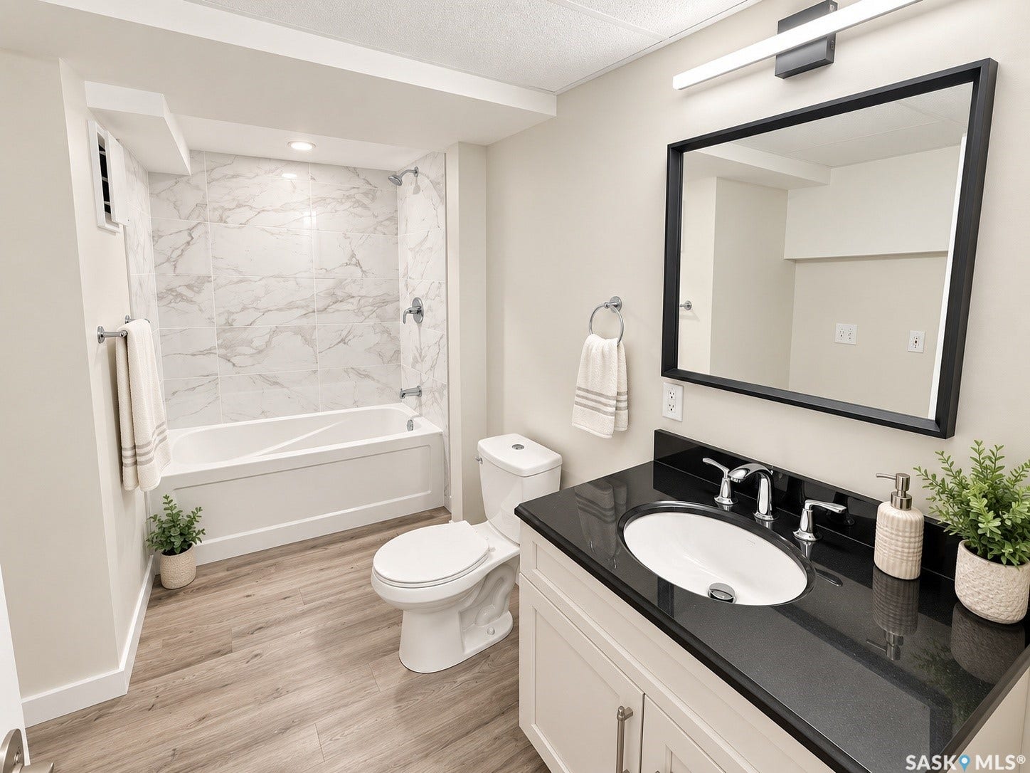 5810 Sherwood Drive, Regina SK S4T 6Y7 White vanity with a black countertop, chrome faucet, and under-mount sink