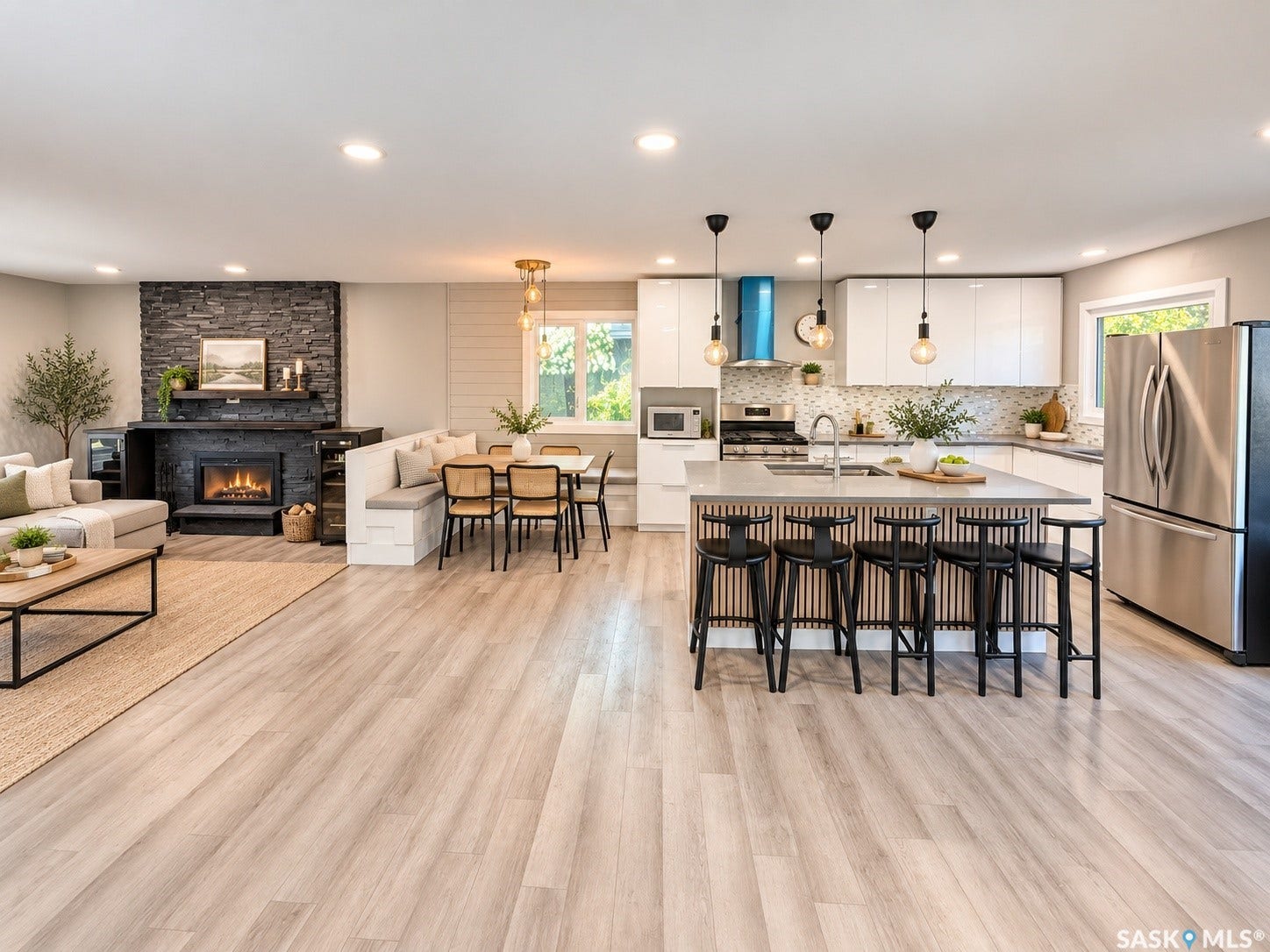 5810 Sherwood Drive, Regina SK S4T 6Y7 Open-concept living area with wood-finish flooring, a stone-clad fireplace, built-in banquette seating, a kitchen island with pendant lighting, and stainless steel appliances