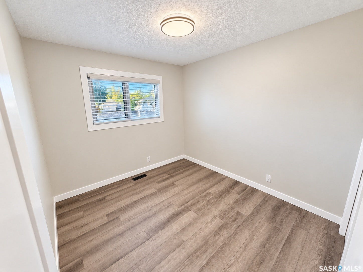 5810 Sherwood Drive, Regina SK S4T 6Y7 Wood-finish flooring, neutral wall tones, and overhead flush-mount lighting