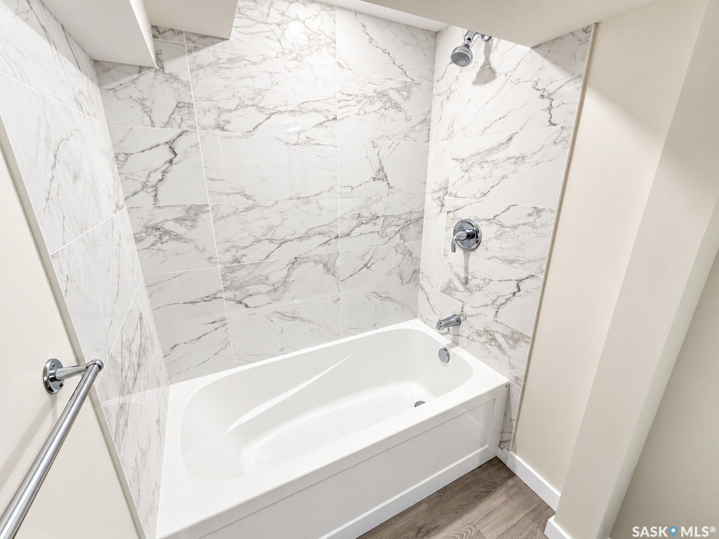 5810 Sherwood Drive, Regina SK S4T 6Y7 White bathtub with chrome fixtures, marble-look tiled walls, and wood-finish flooring