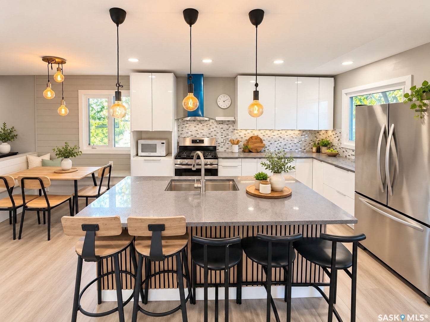 5810 Sherwood Drive, Regina SK S4T 6Y7 Contemporary kitchen featuring a center island with integrated sink, stainless steel appliances, white flat-panel cabinetry, and a mosaic tile backsplash