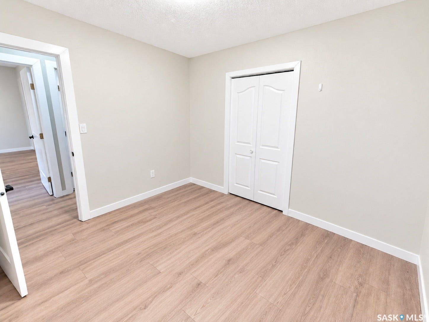 5810 Sherwood Drive, Regina SK S4T 6Y7 Wood-finish flooring, neutral wall tones, and bi-fold closet doors