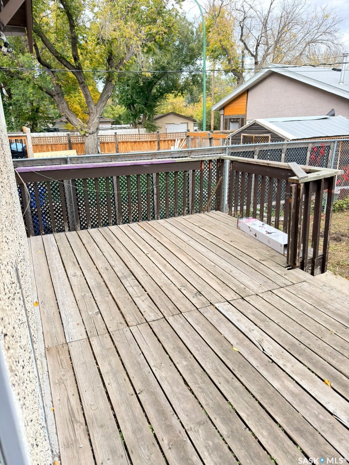 Wood-plank outdoor deck with dark wood-stained railing and lattice