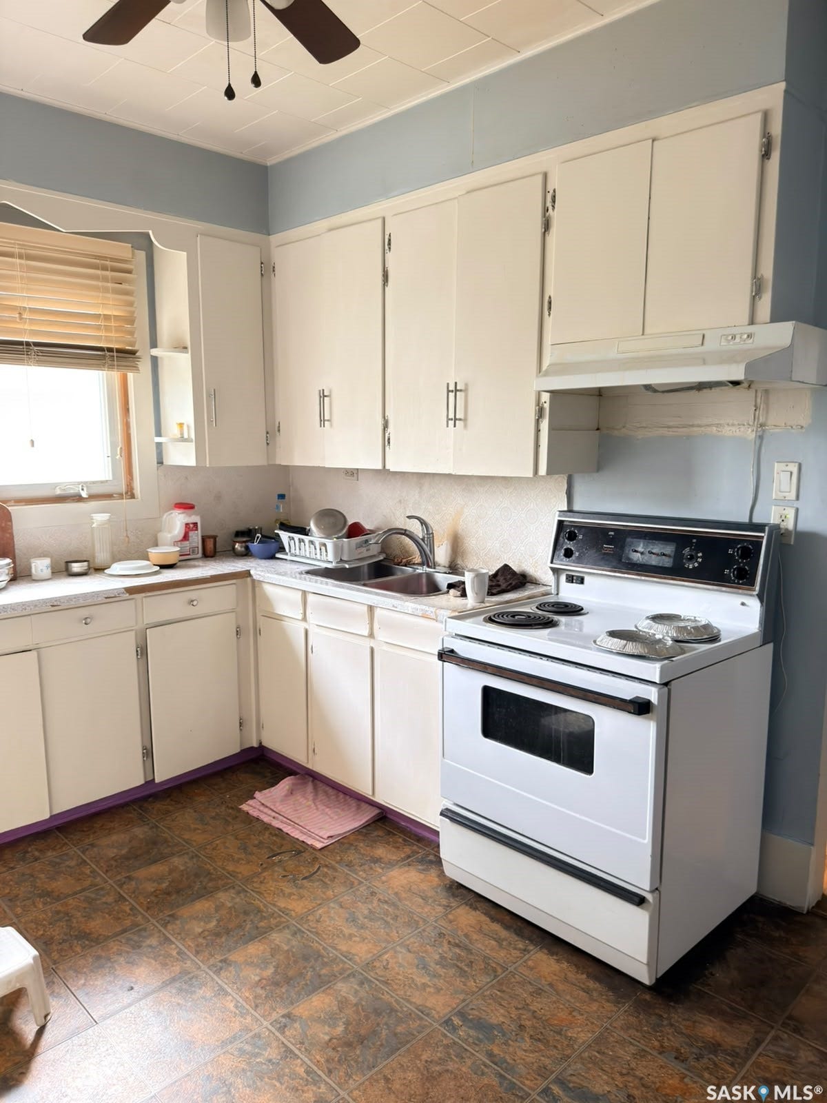 Kitchen featuring white cabinetry, a white range with a matching range hood, and a ceiling fan