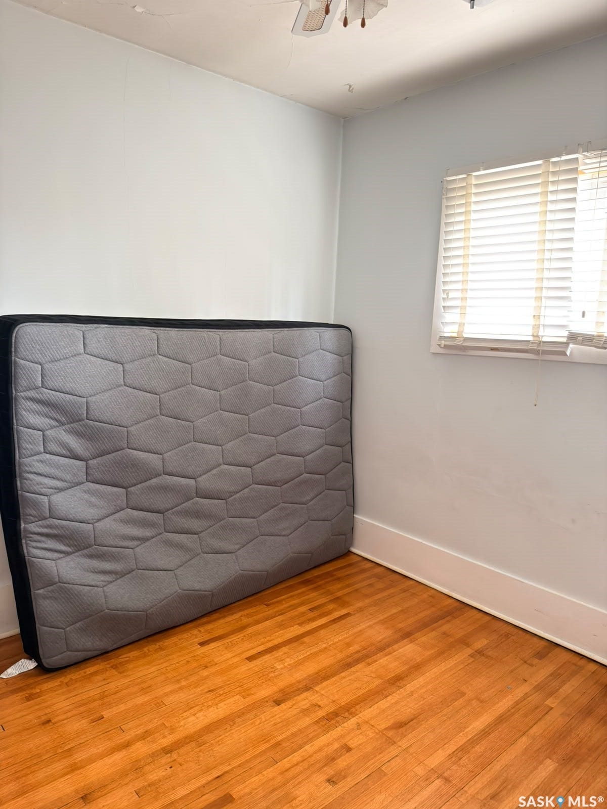 Hardwood flooring and a window with blinds