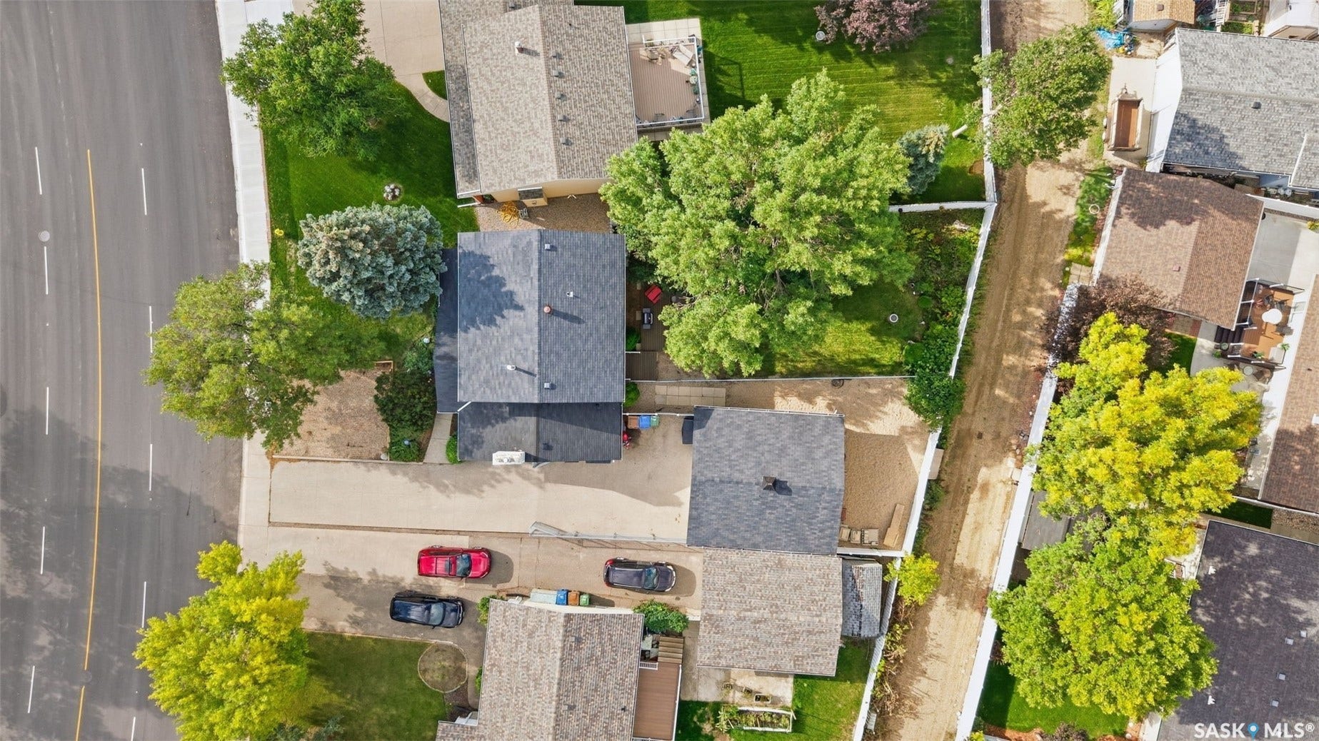Property featuring multiple structures, paved driveways, and established landscaping