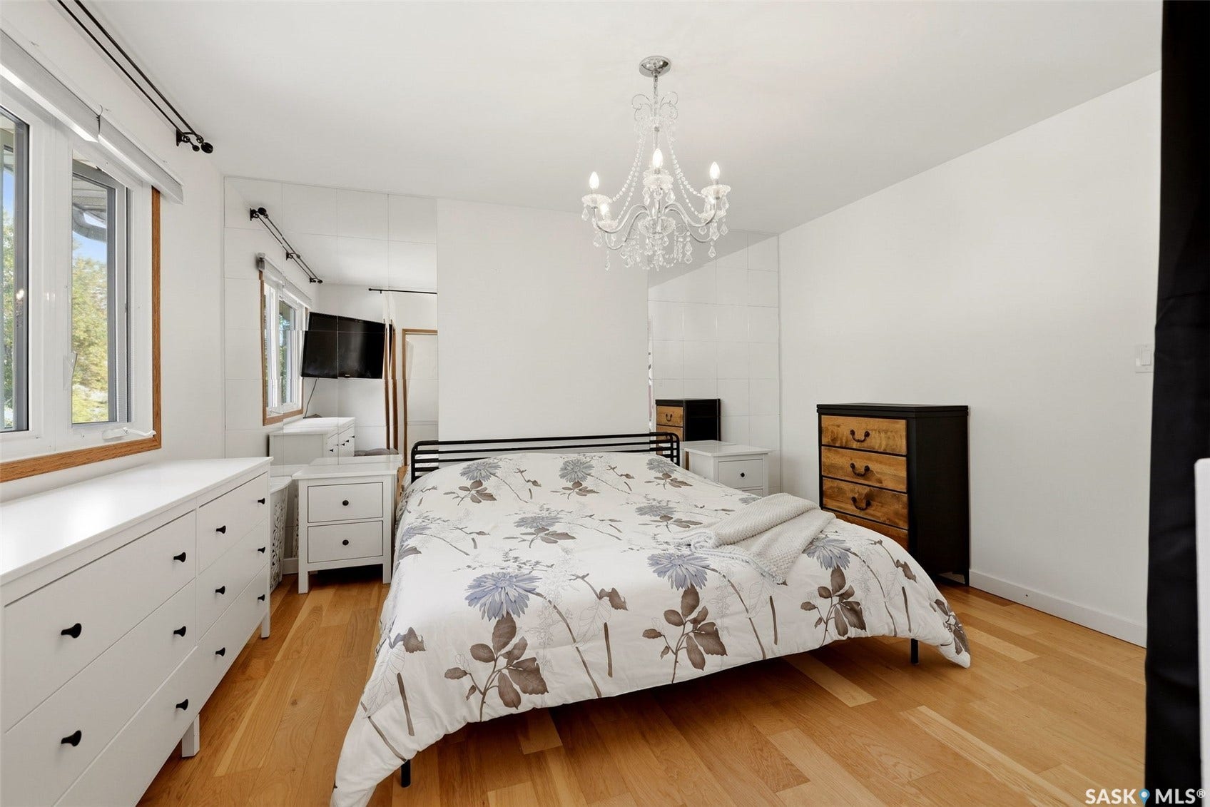 Hardwood flooring throughout, multiple windows with wood sills, and a crystal chandelier