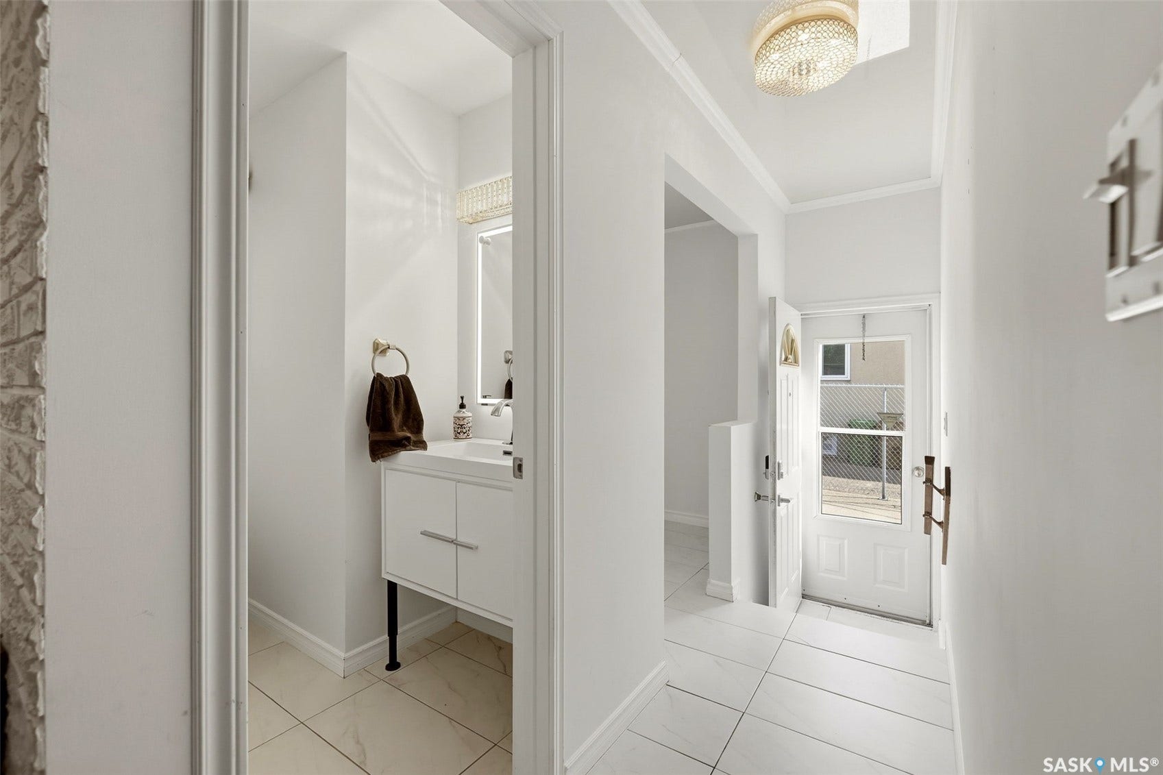 Entryway featuring tile flooring, white walls, and a front door with a glass insert