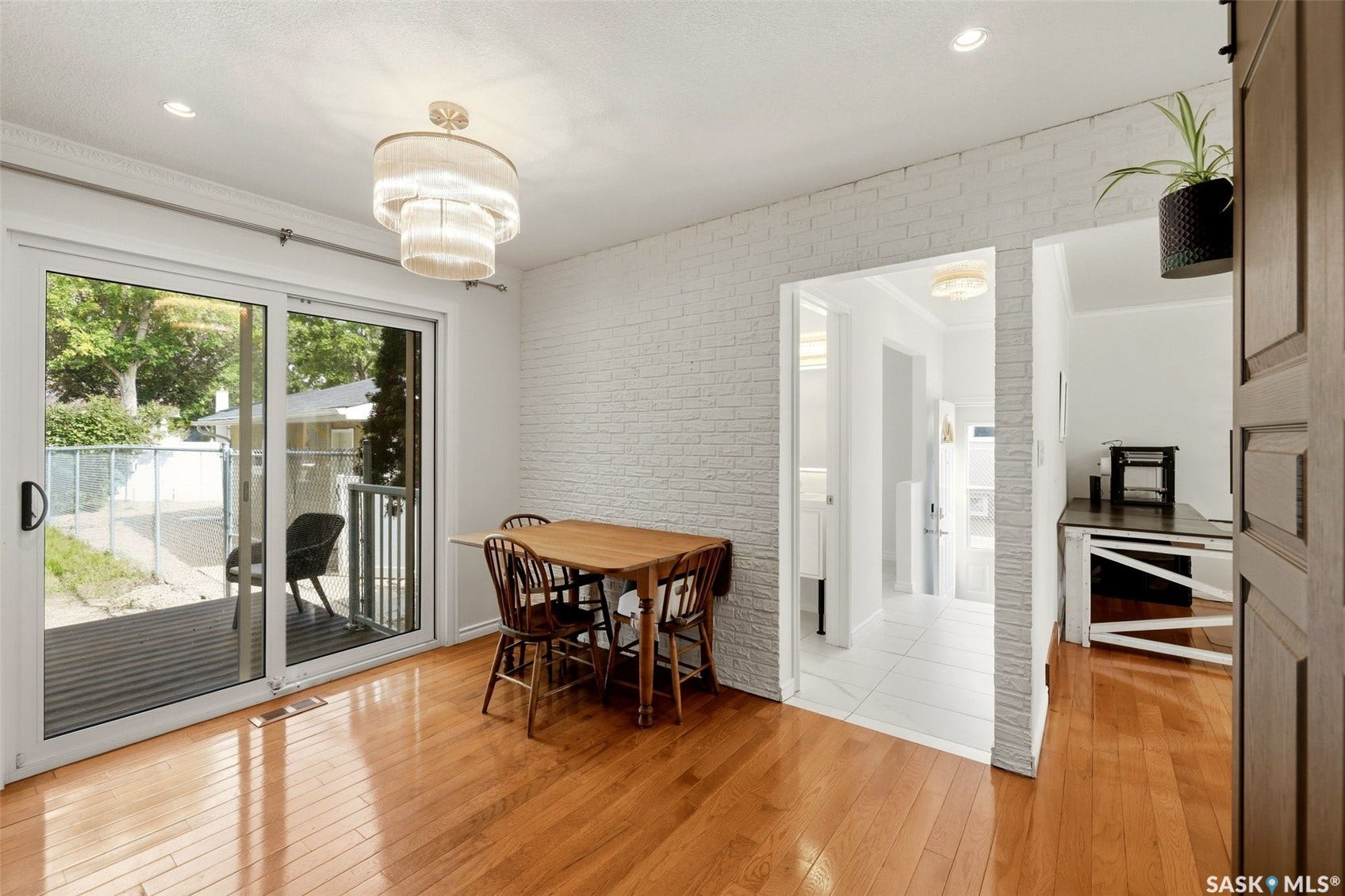 Hardwood flooring, sliding glass door leading to an outdoor deck, recessed lighting, and a decorative light fixture