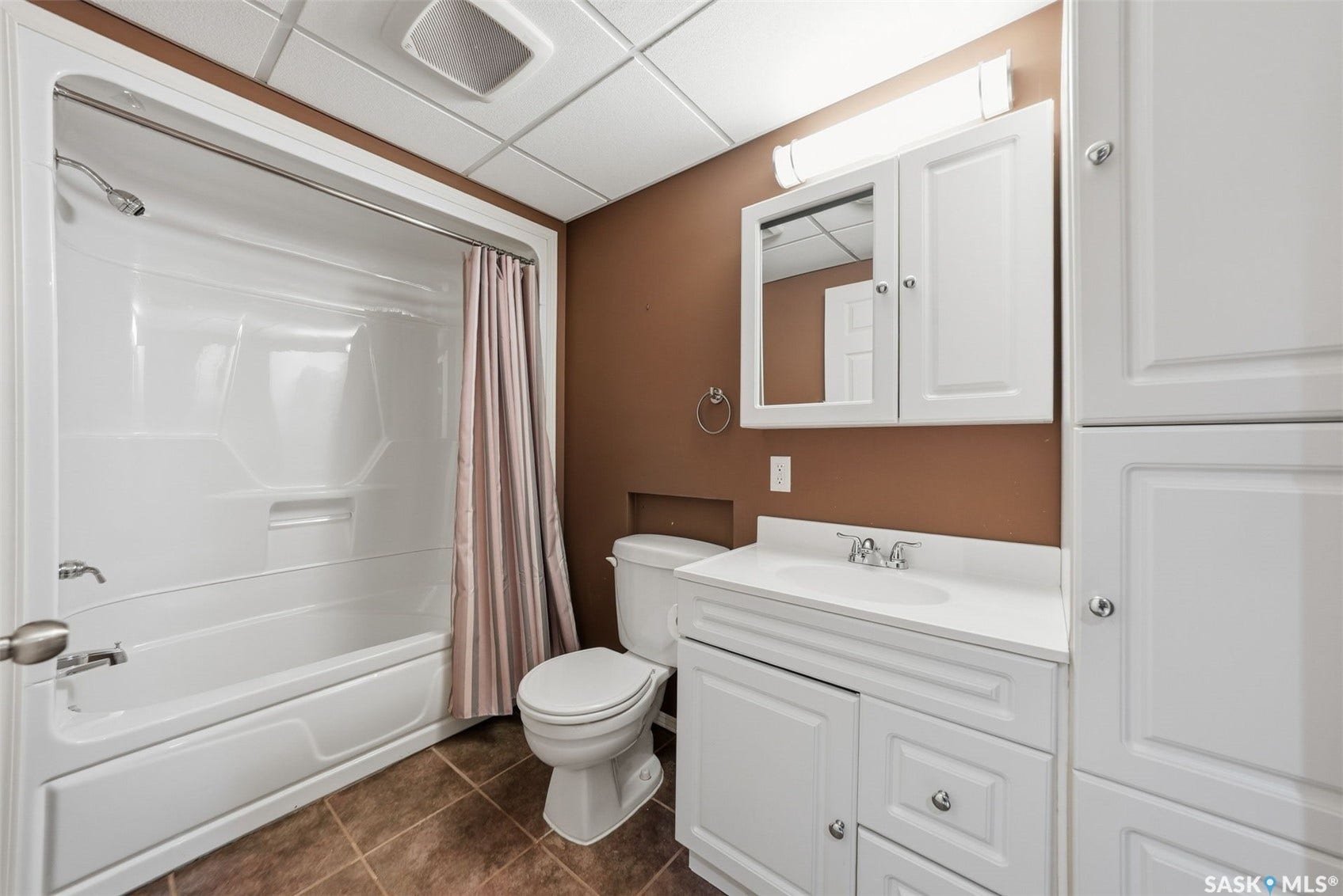 White vanity with a single basin sink and chrome fixtures