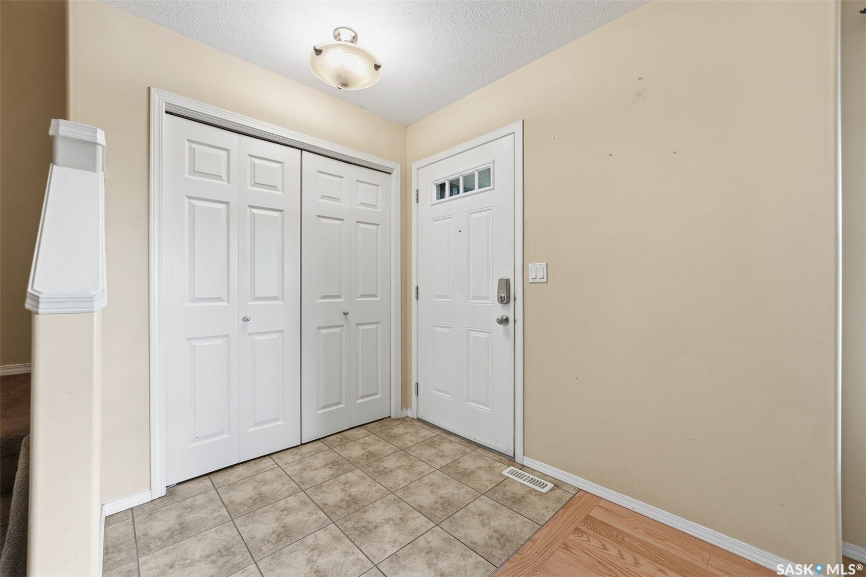 Tile flooring entryway with an overhead flush-mount light fixture
