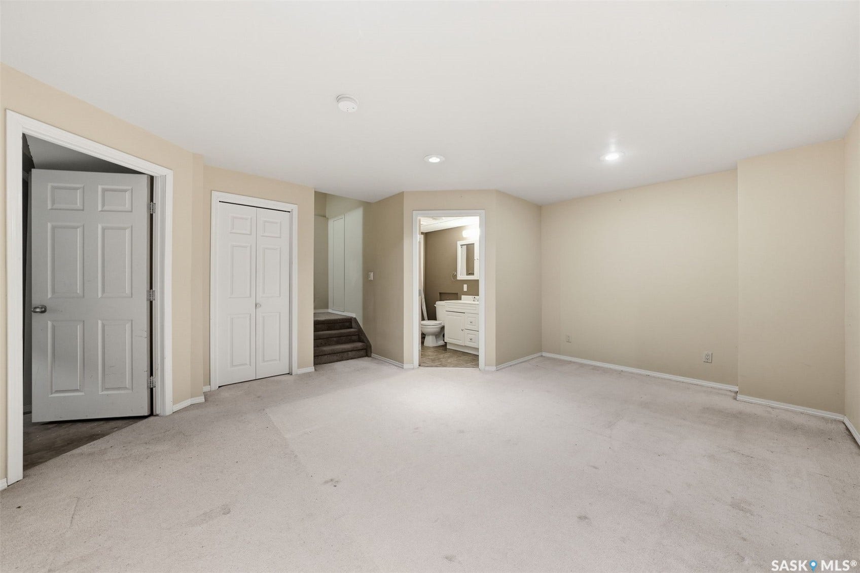 Carpeted room with recessed lighting and a white bi-fold closet
