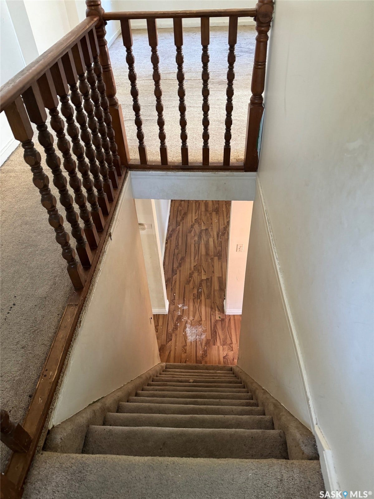 Carpeted staircase with wood railing