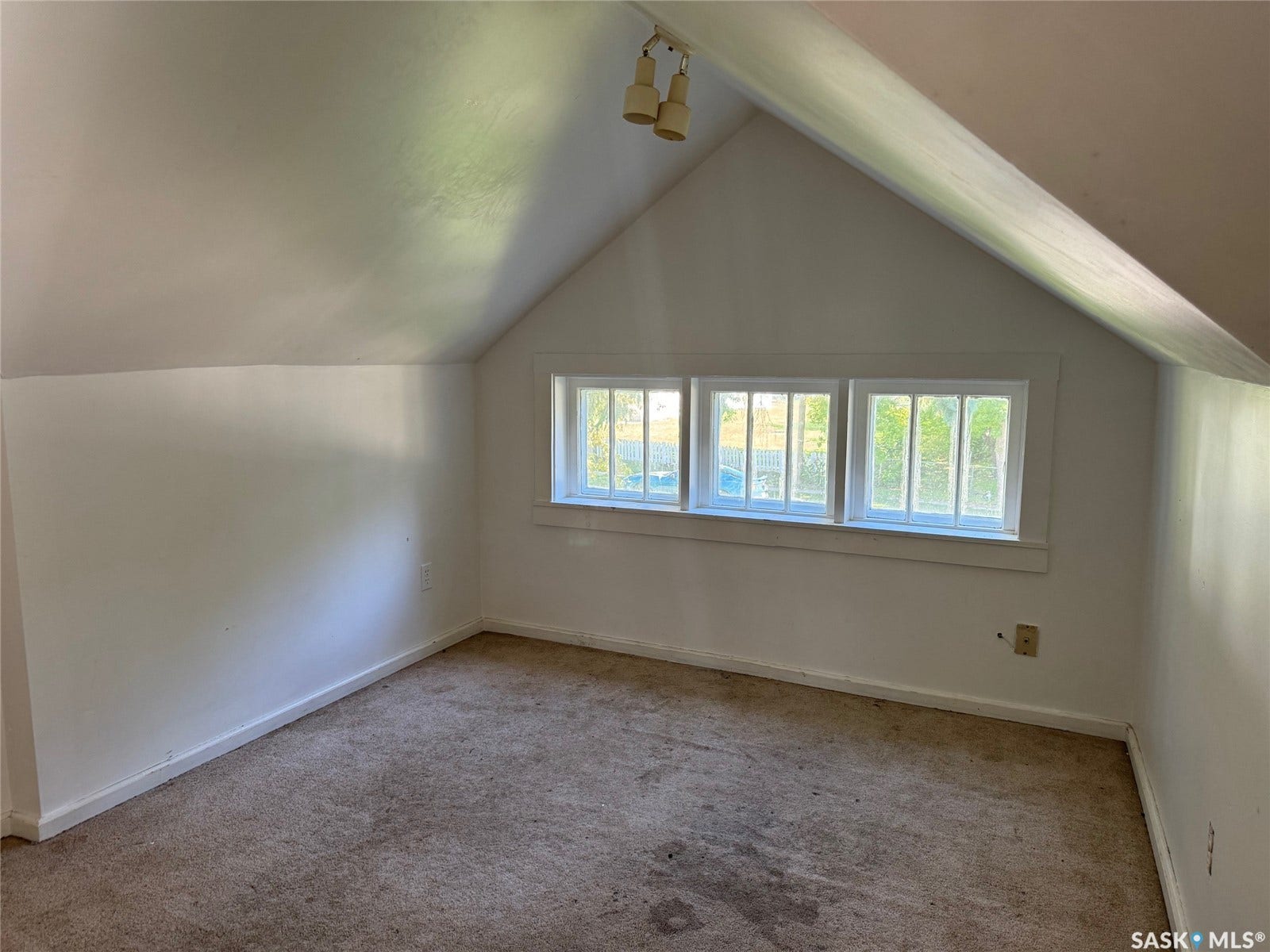 Triple window feature with white trim and a sloped ceiling