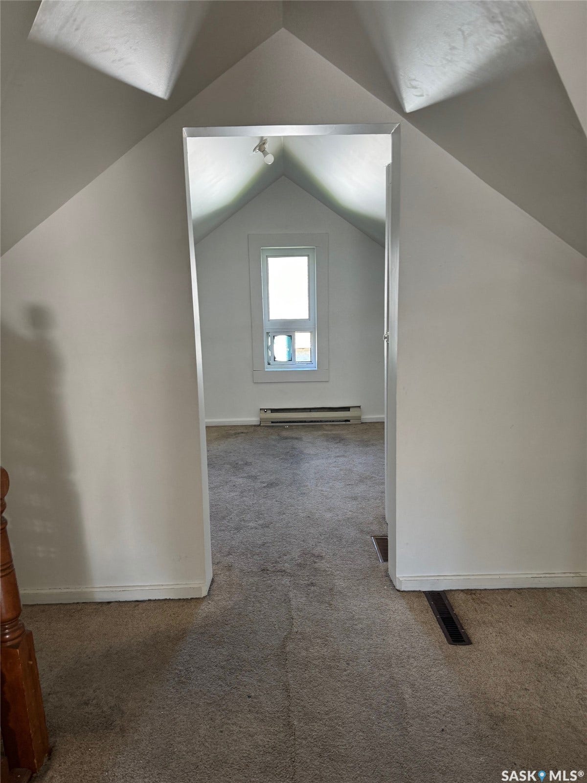 Sloped ceilings, window, wall-mounted light fixture, carpeting