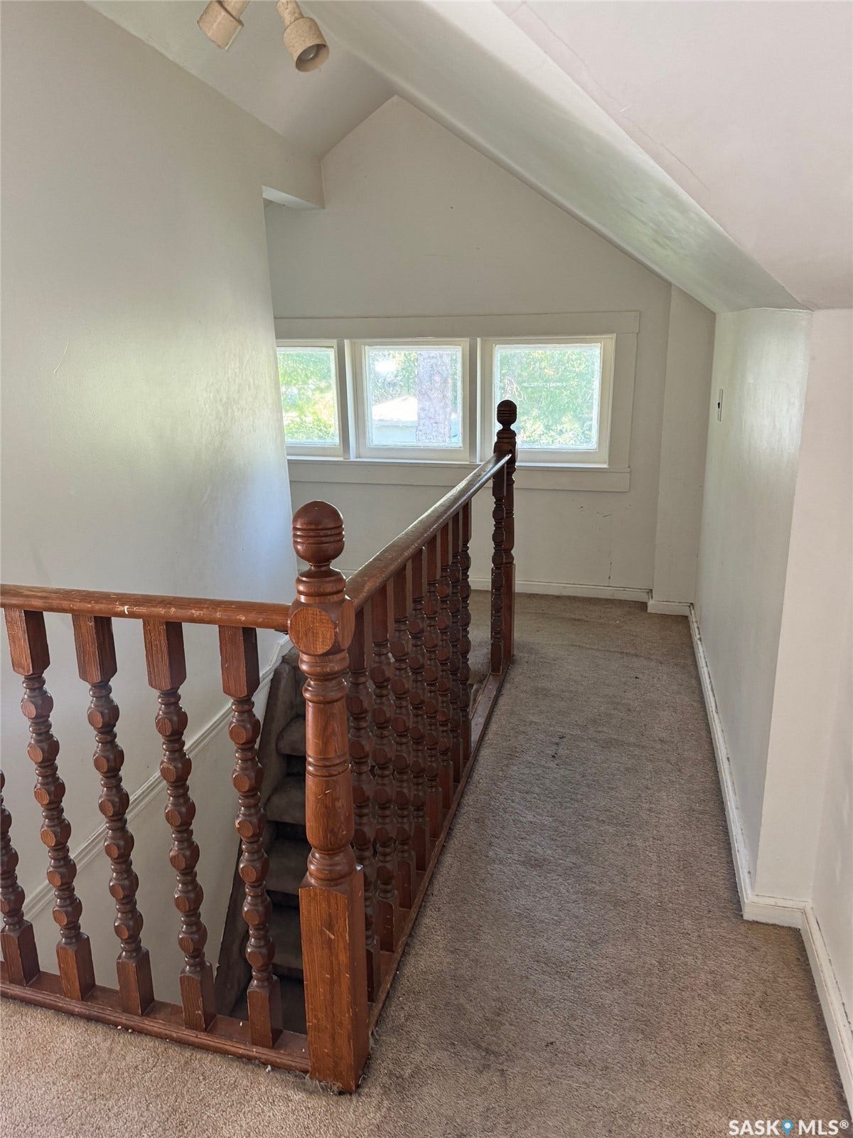 Carpeted hallway with three framed windows