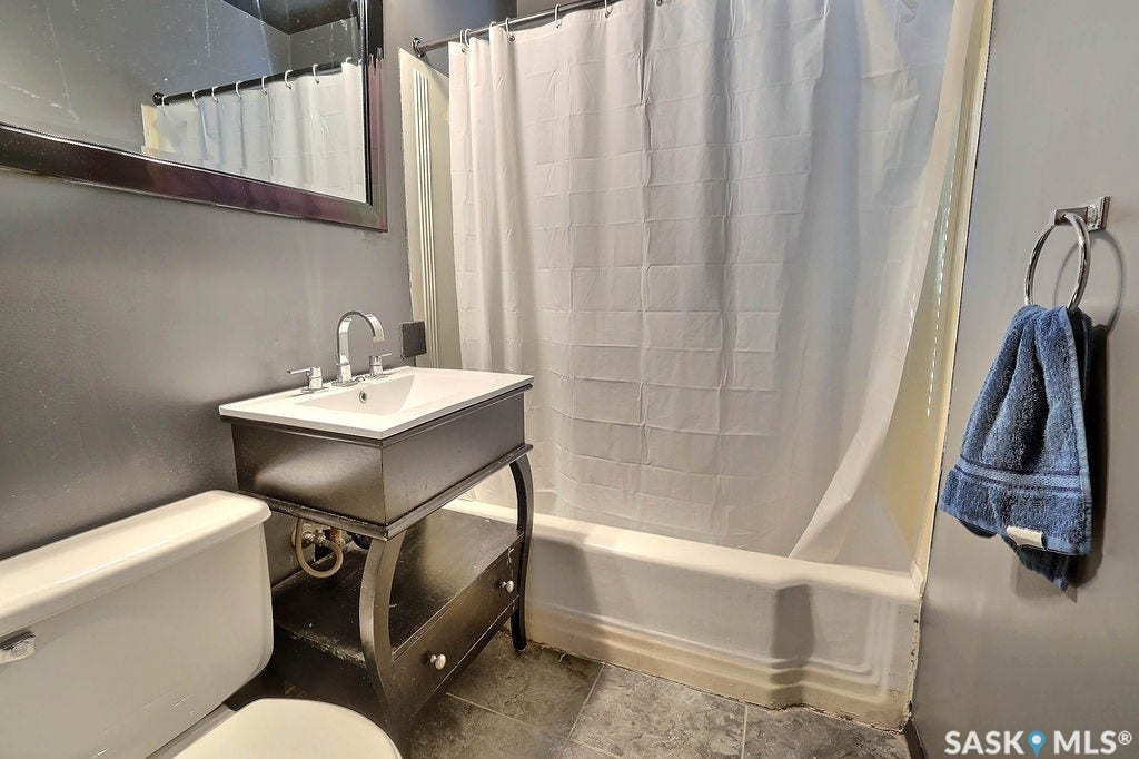 Bathroom featuring a pedestal vanity with an integrated sink, polished chrome faucet, and a wall-mounted mirror