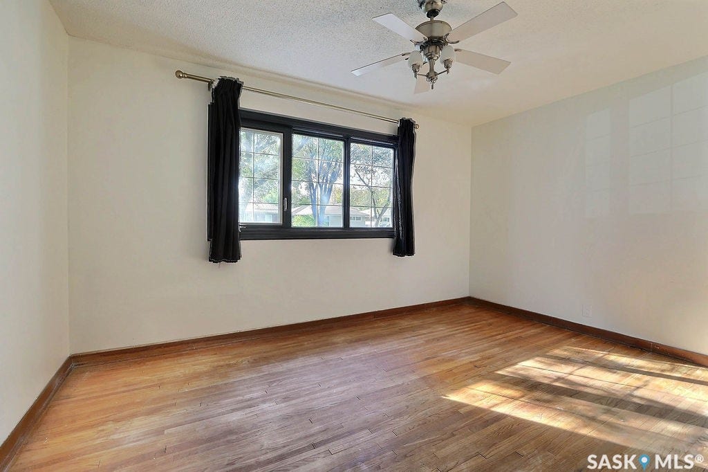 Hardwood flooring, painted walls, large window, and ceiling fan with integrated lighting