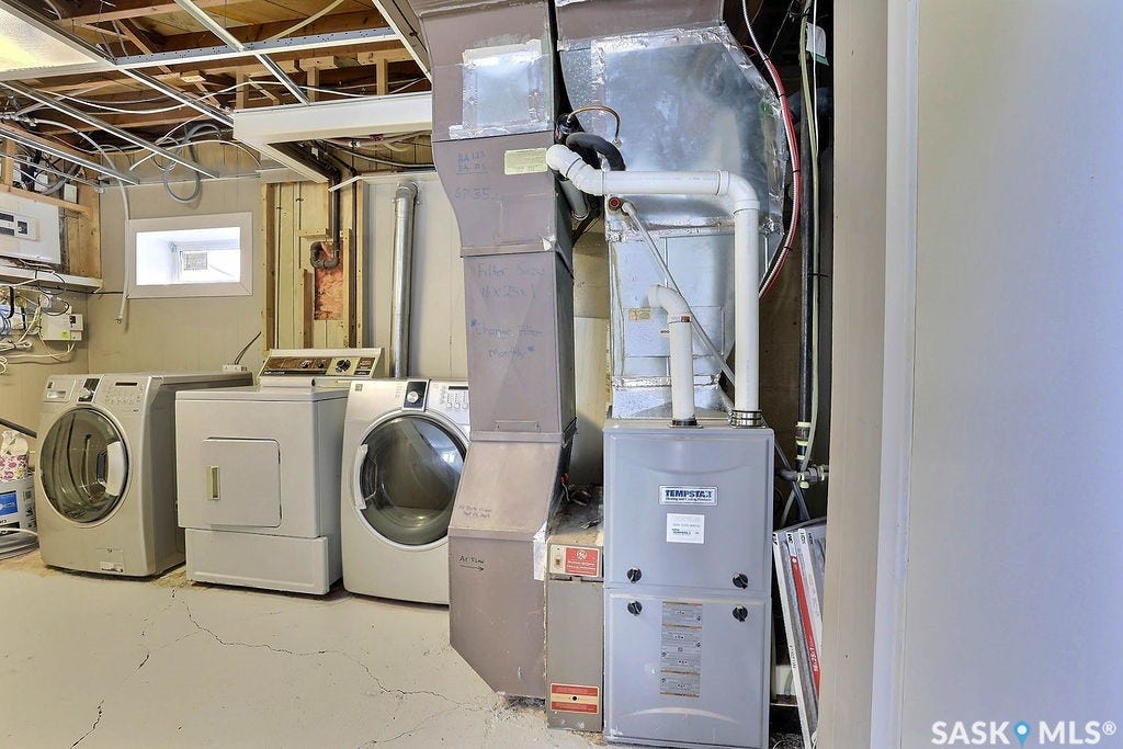 Utility room featuring a furnace, water heater, and exposed ceiling joists