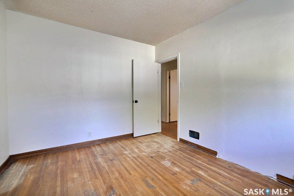 Wood-finish flooring with white walls and a white ceiling