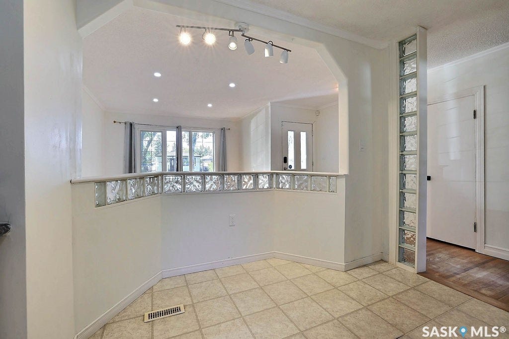Tiled flooring, glass block wall features, recessed lighting, and a track lighting fixture