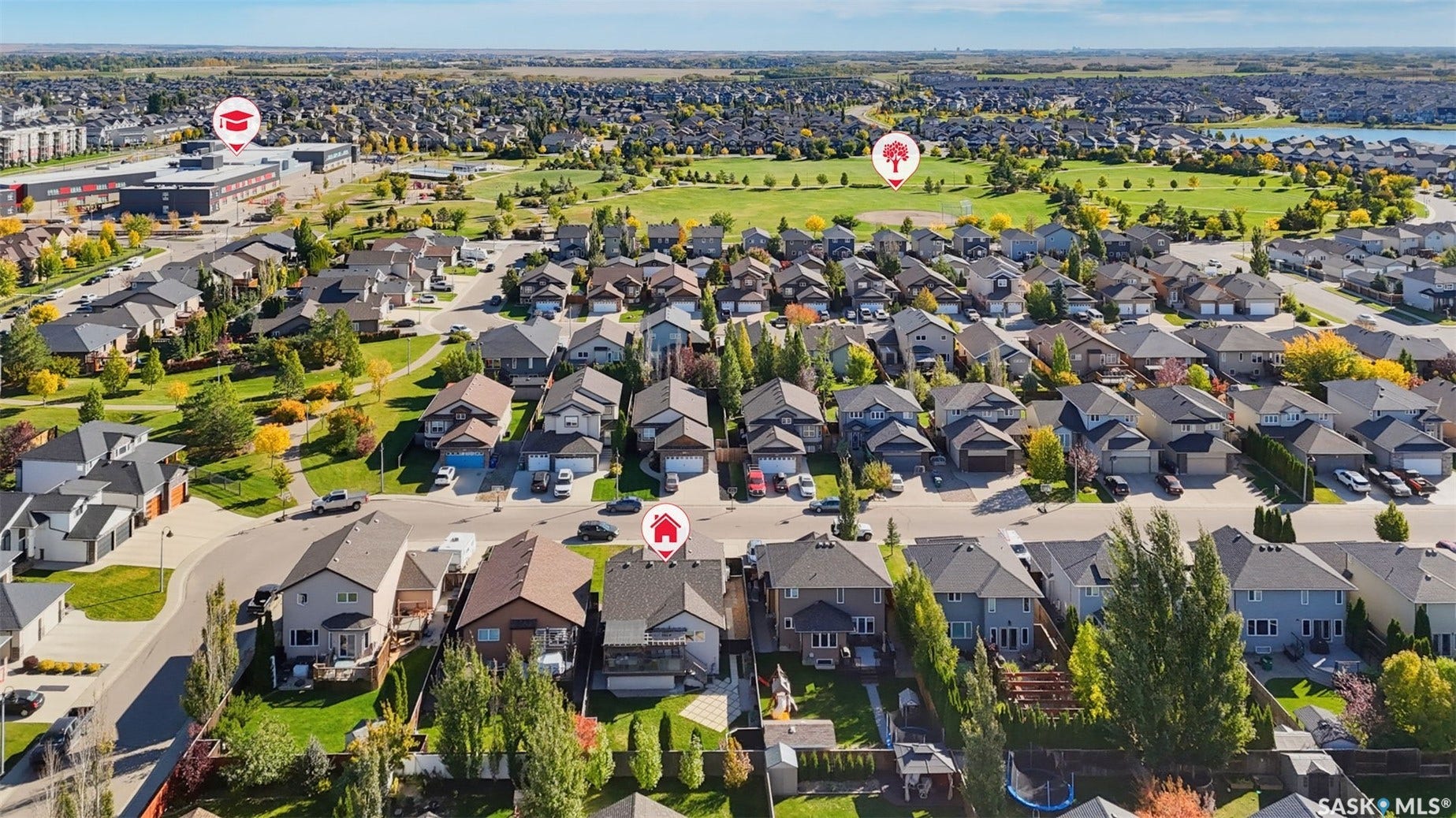 Residential neighborhood featuring single-family homes, expansive green spaces, and a nearby body of water