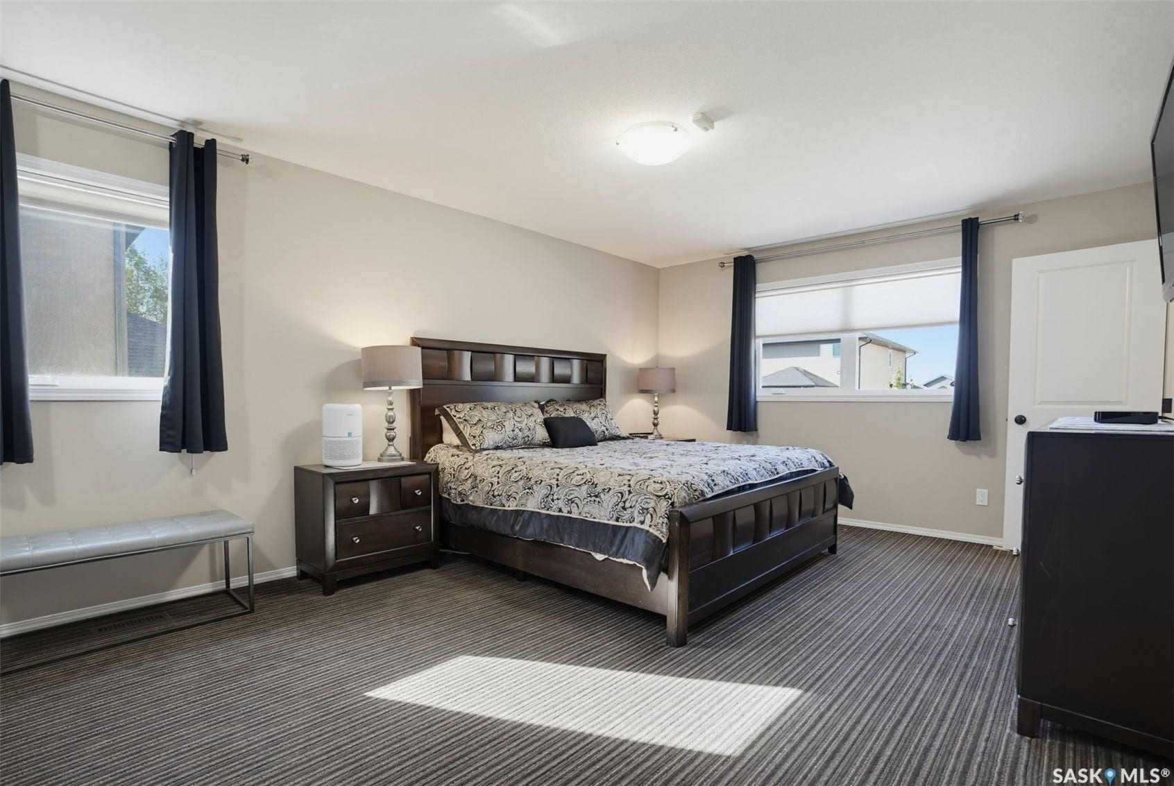 Striped carpet flooring with multiple windows and light-toned walls
