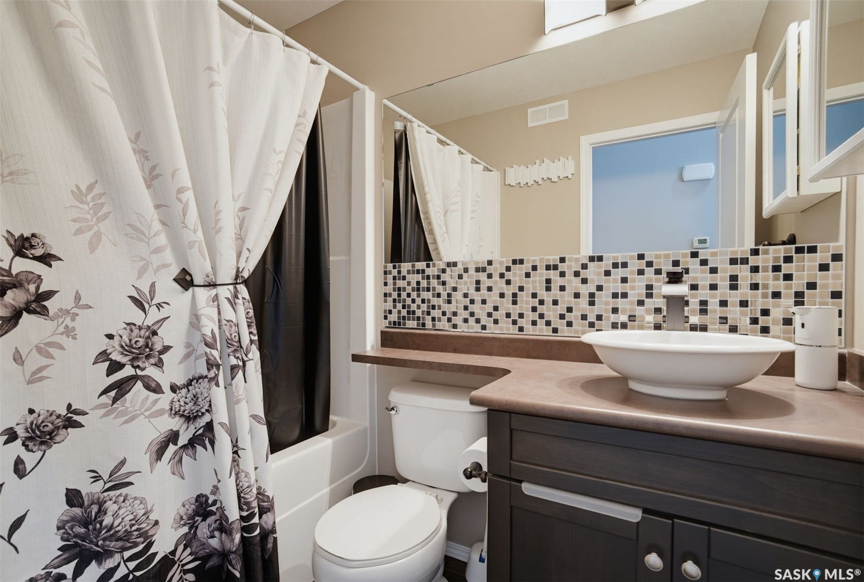 Vanity with a vessel sink, dark wood-finish cabinetry, and solid surface countertop