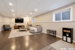 Recessed ceiling lighting, wood-finish flooring, drop ceiling, white window trim, and a built-in wall shelf-- AI generated