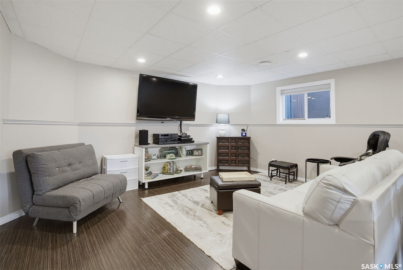 Recessed lighting, wood-finish flooring, white trim, and a window
