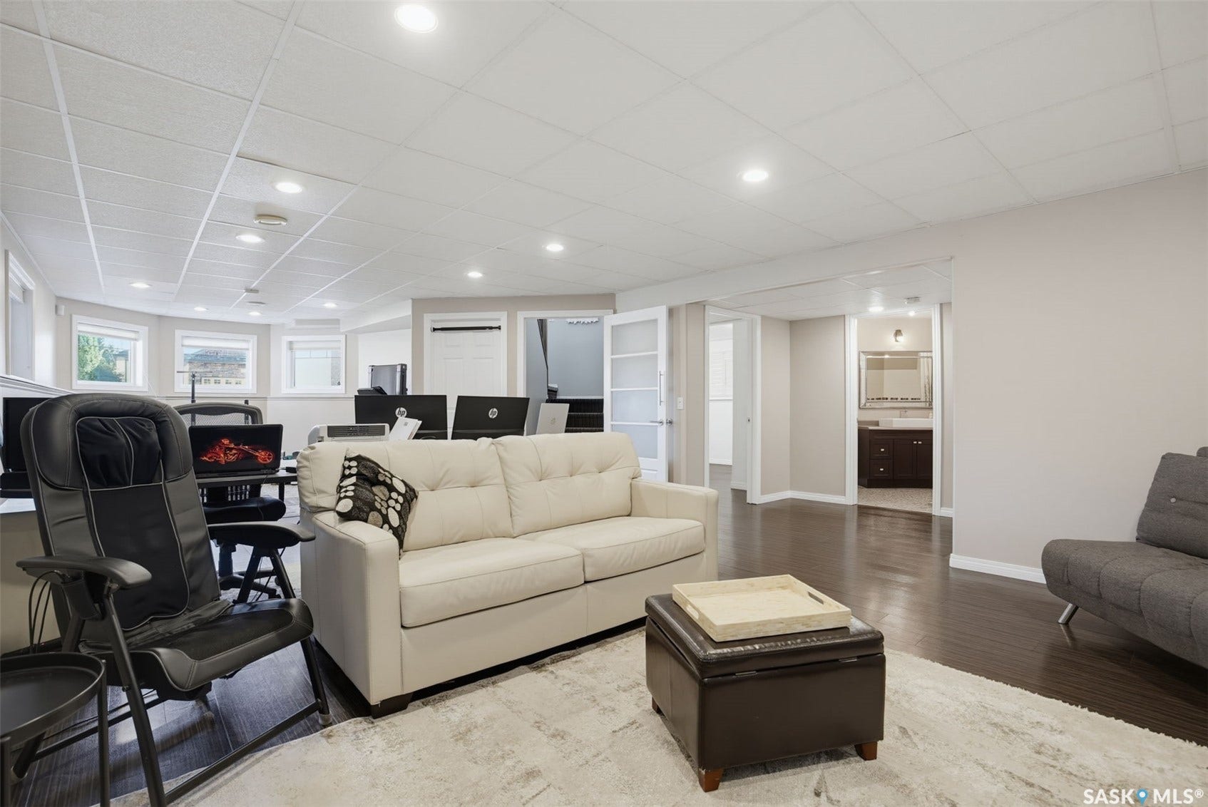 Spacious open area featuring dark wood-finish flooring, recessed lighting, and a drop ceiling